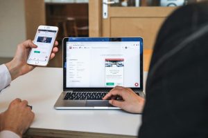Người dùng kiểm tra độ tin cậy của một website cá cược trên điện thoại và laptop